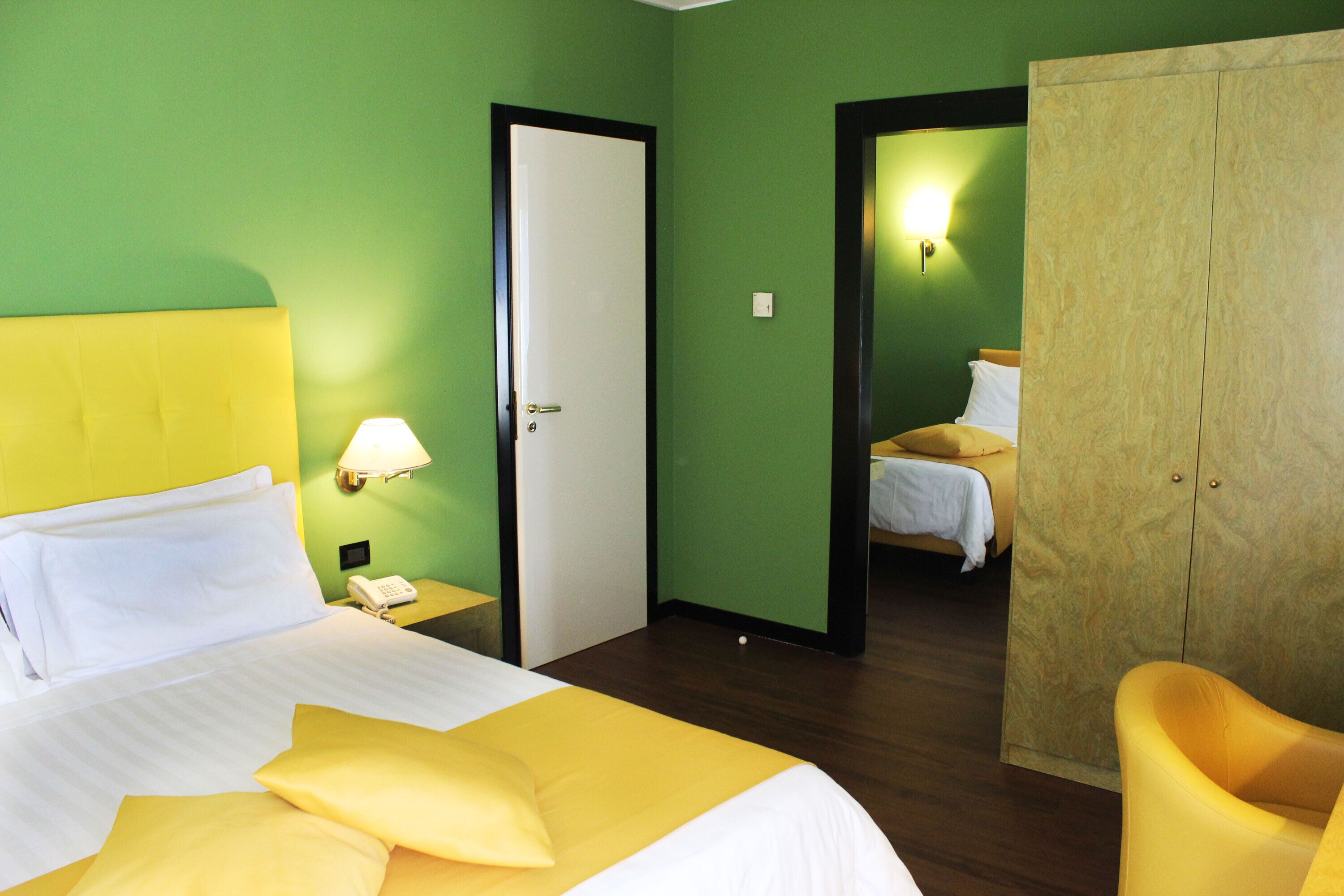 Une chambre d’hôtel avec un lit, une chaise, une armoire et une porte.