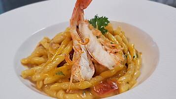 Eine Pasta-Zubereitung mit Garnelen und Garnitur.