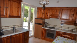 Una cocina con armarios de madera, un refrigerador de acero inoxidable y salpicadero de azulejos.