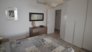 Un dormitorio con cama, cómoda, espejo y armario.