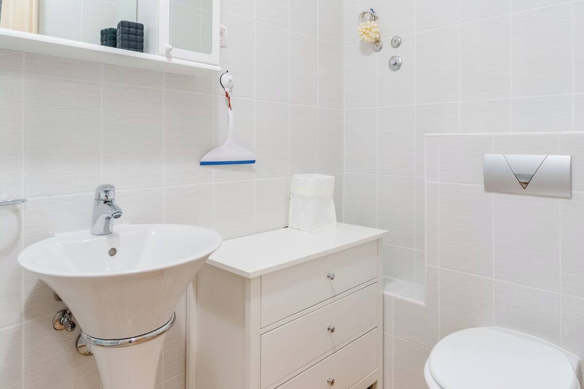 Ein Badezimmer mit weißem Waschbecken, Waschtisch und Toilette.
