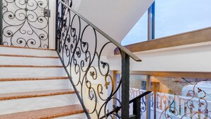 Eine Treppe mit Marmorverkleidung und aufwendigen schwarzen Metallgeländern.