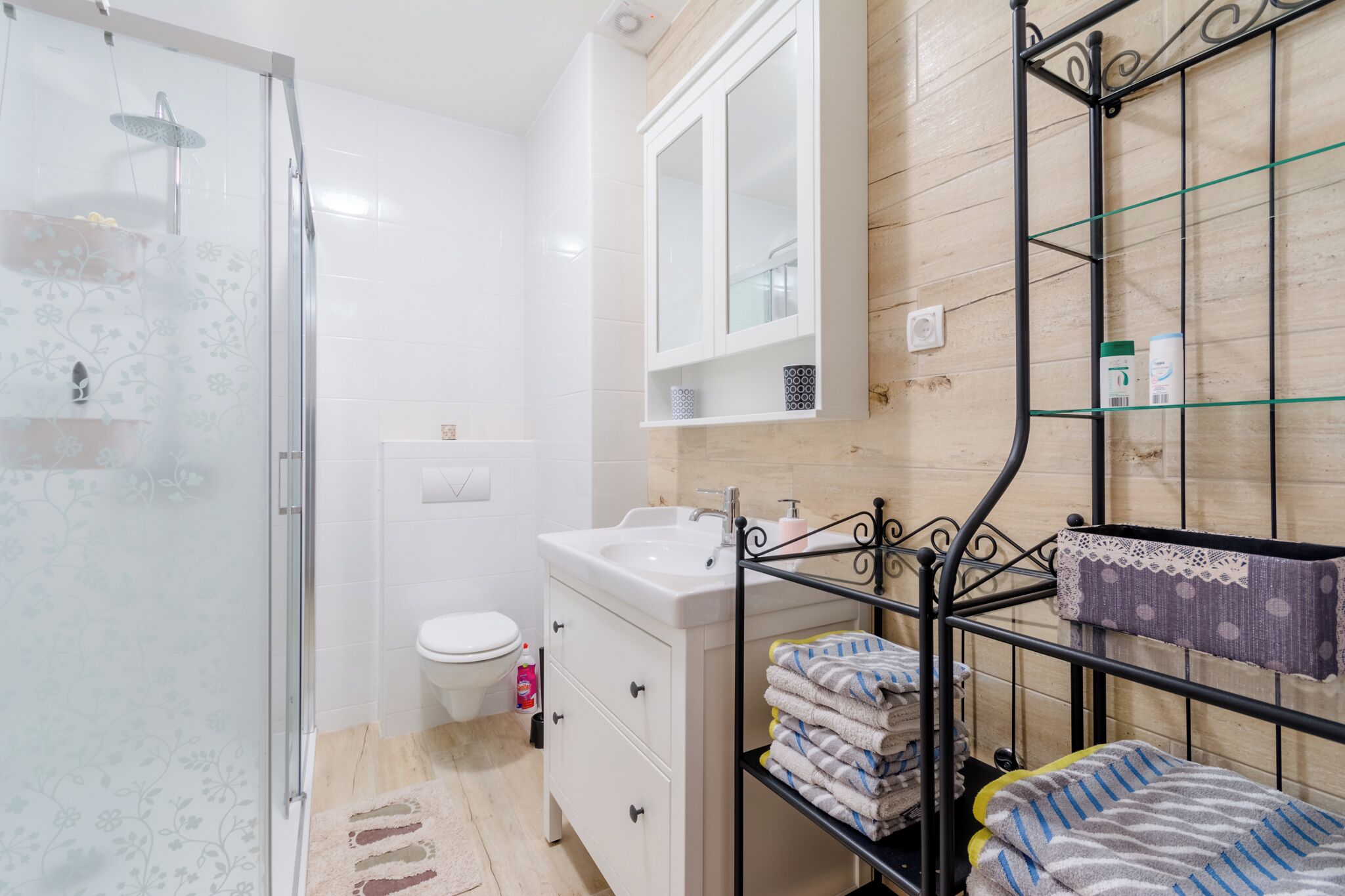 Une salle de bain équipée d’une douche, de toilettes, d’un lavabo et d’un porte-serviettes en métal.