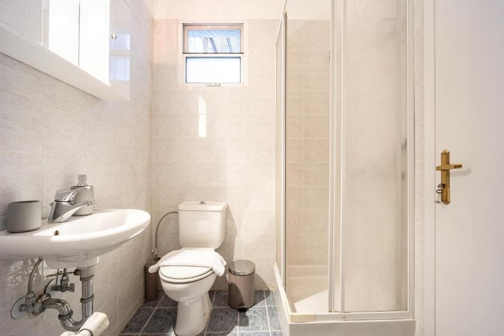 Une salle de bain avec un lavabo, des toilettes et une douche.