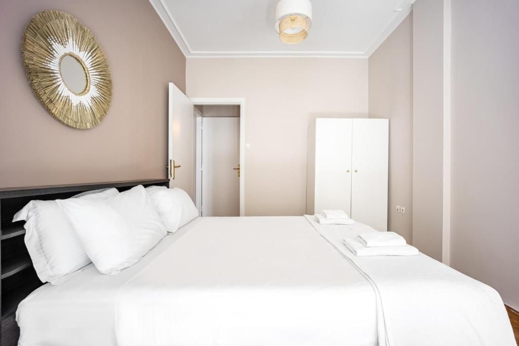 Ein Hotelzimmer mit einem großen Bett, einem Kleiderschrank, einem Spiegel und einem Wanddekor.
