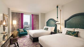 Une chambre d’hôtel avec deux lits, un bureau, une chaise et une vue sur la ville.