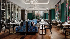 Un restaurant doté d’un espace central pour les clients, de plusieurs tables et d’un présentoir à vins.