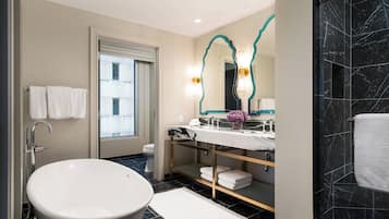 A modern bathroom with a freestanding bathtub, a vanity with a mirror, and a toilet.