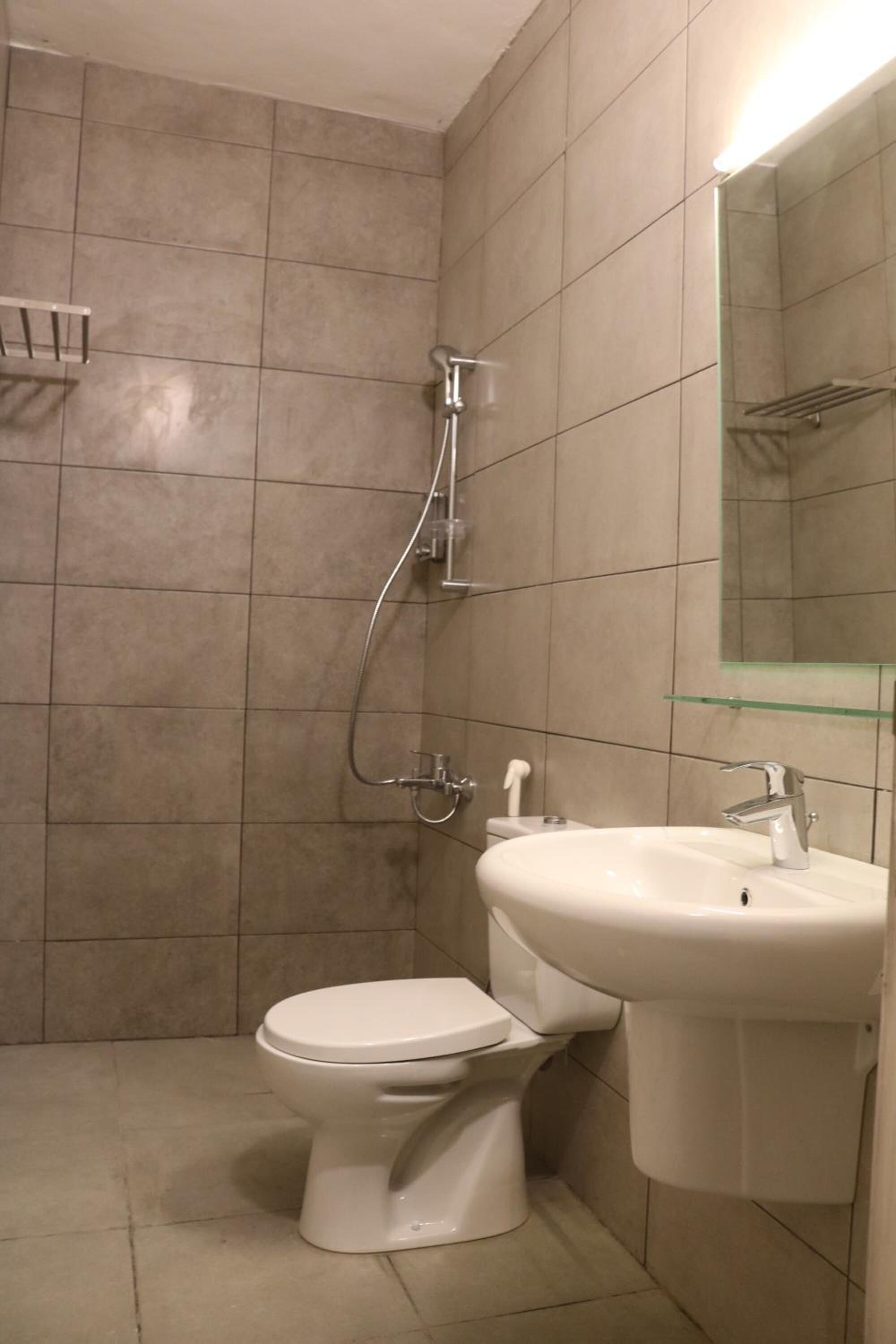 A bathroom with a toilet, a sink, and a shower.
