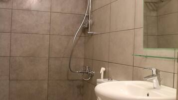 A bathroom with a toilet, a sink, and a shower.