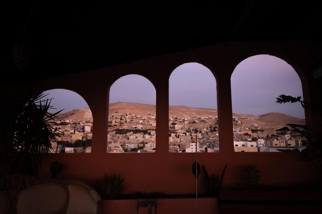 Una habitación con vistas a un paisaje urbano a través de ventanales arqueados.