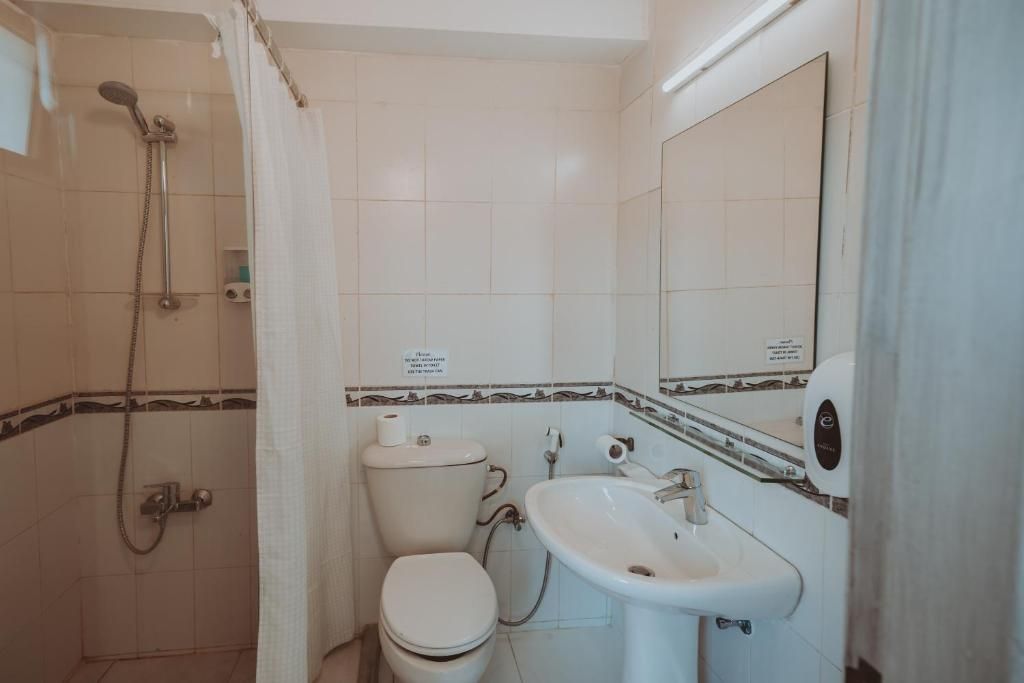 A bathroom with a shower, toilet, and sink.