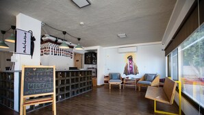 A modern interior with a reception desk, seating area, and artwork on the wall. - Nomads Hotel Petra (Wadi Musa)