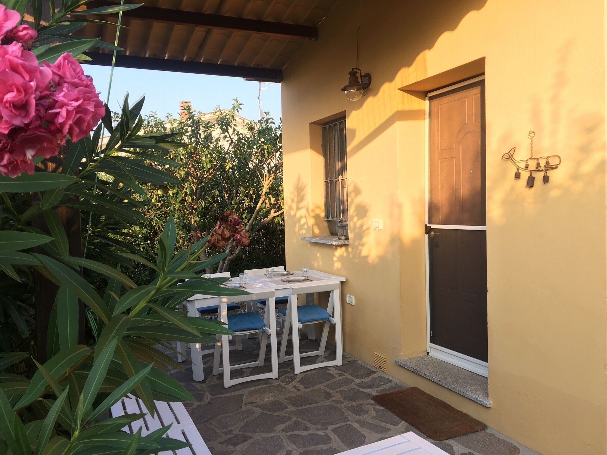 Un patio con una mesa, sillas, una puerta y una ventana.