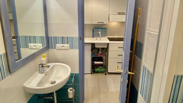 A compact bathroom with a sink, mirror, and toilet.
