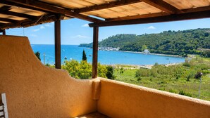 A covered outdoor seating area with a view of a coastal landscape. - Il Portolano (Porto Azzurro)