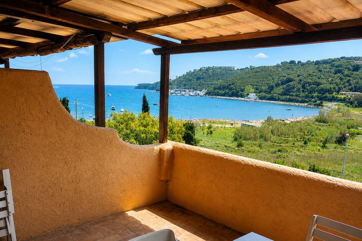 Uma área de estar coberta ao ar livre com vista para a paisagem costeira.