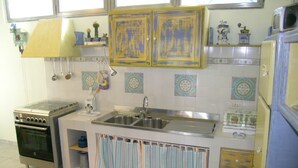 A kitchen with a stove, sink, and cabinets. - Silvia (Capoliveri)