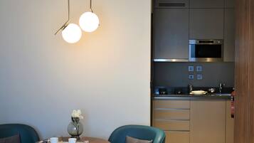 Una cocina moderna con electrodomésticos de acero inoxidable, un comedor con una mesa redonda y sillas, y un jarrón con flores sobre la mesa.