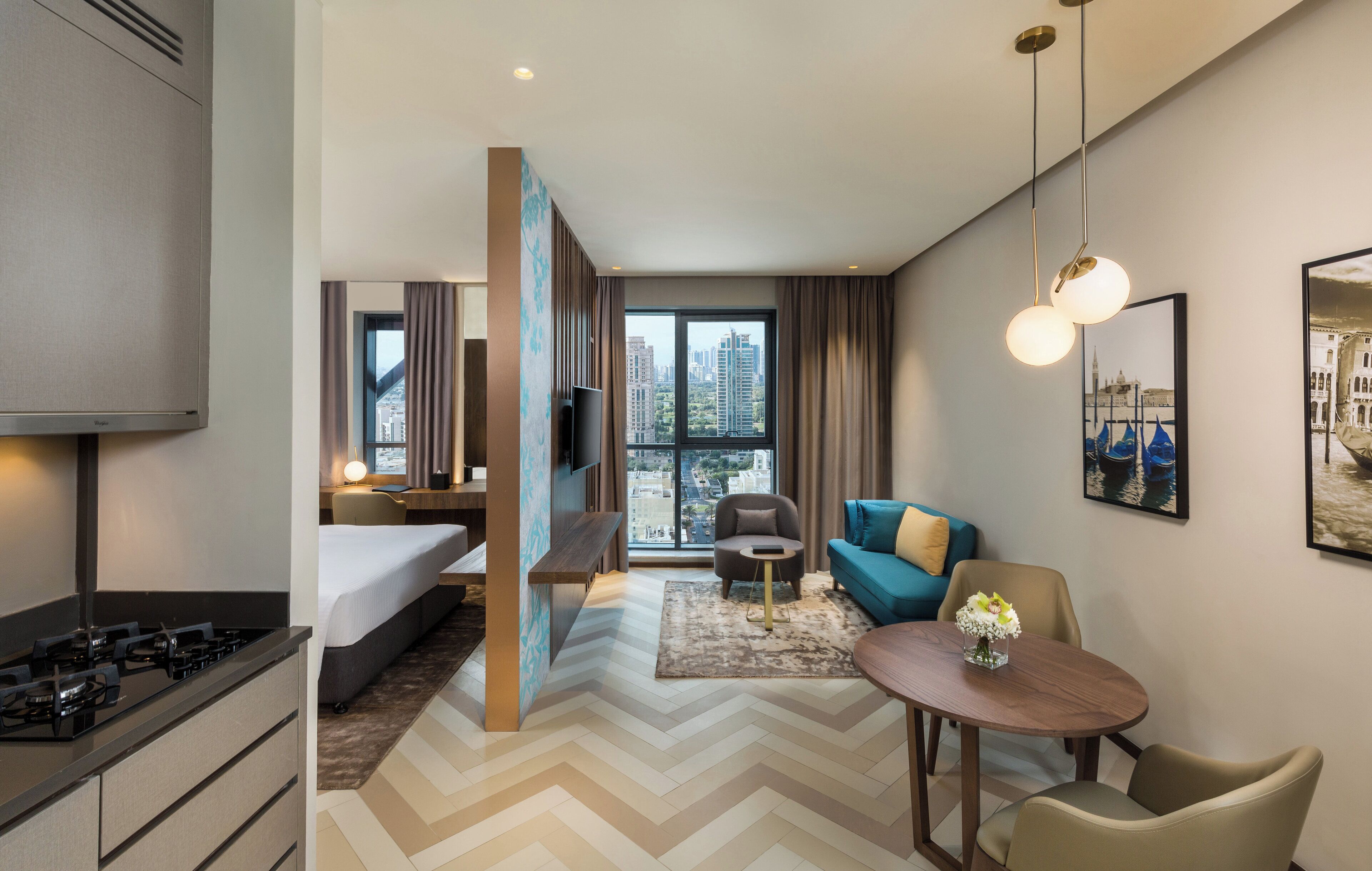 A hotel room with a bed, a desk, a chair, a dining table, and a TV.