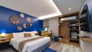 A modern bedroom with a bed, bedside tables, a wardrobe, and a television. - Aspira One Sutthisan (Bangkok)
