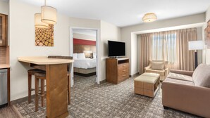 A hotel room with a kitchenette, a bed, a TV, a sofa, and a dining area. - Staybridge Suites Hillsboro - Orenco Station by IHG (Hillsboro)