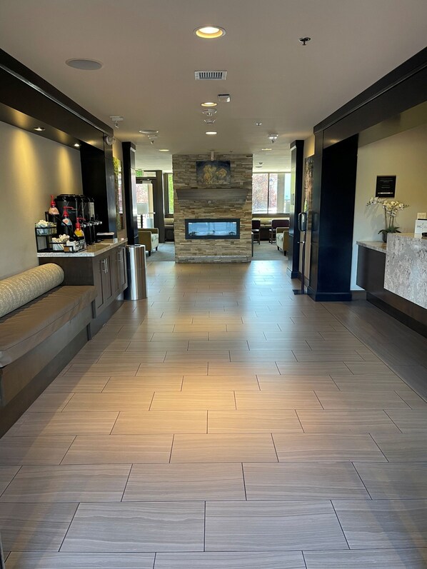 A spacious lobby with a stone fireplace, seating areas, and a coffee station. - Staybridge Suites Hillsboro - Orenco Station by IHG (Hillsboro)