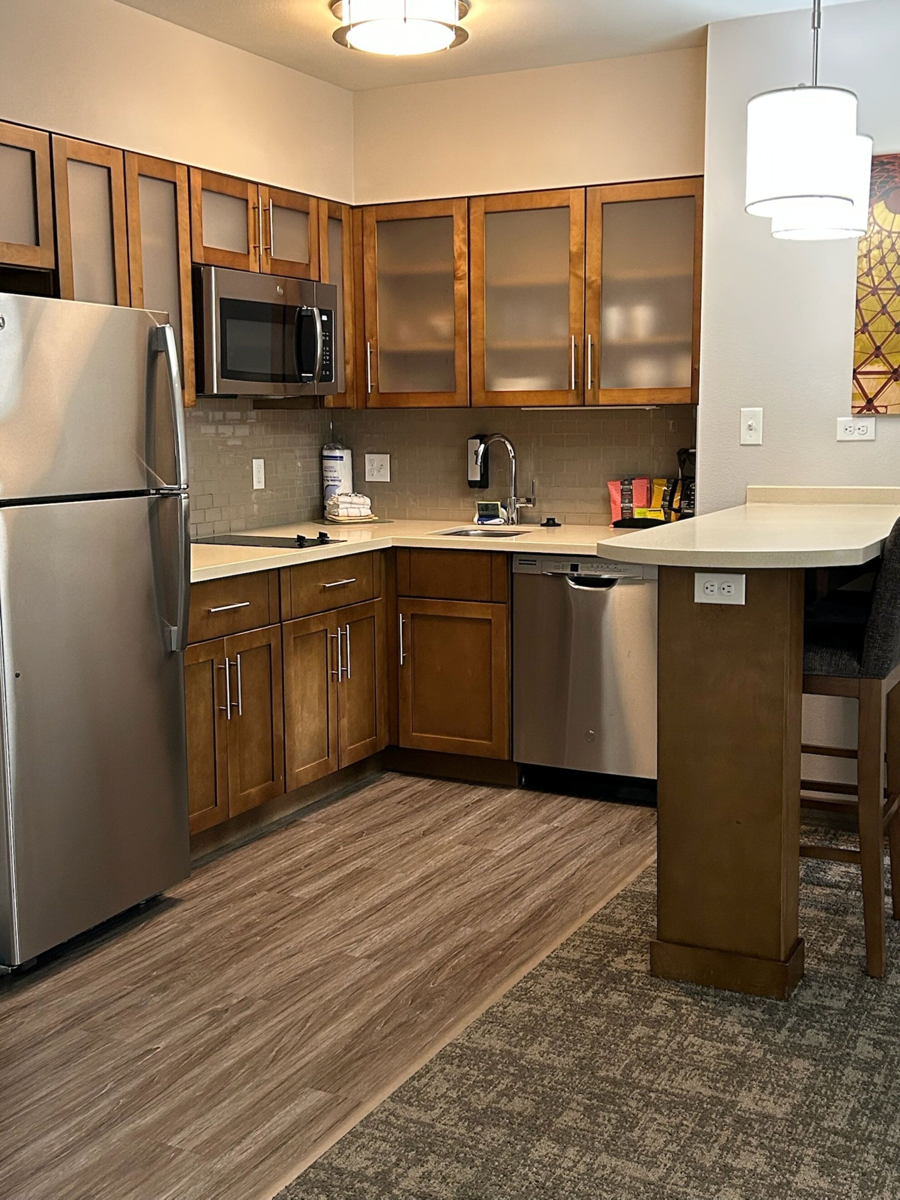 A modern kitchen with wooden cabinets, stainless steel appliances, and a central island.