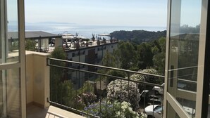 A balcony with a view of a coastal area, including buildings and a body of water. - VerdeBlu (Capoliveri)