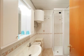A bathroom with a sink, mirror, and shower. - VerdeBlu (Capoliveri)
