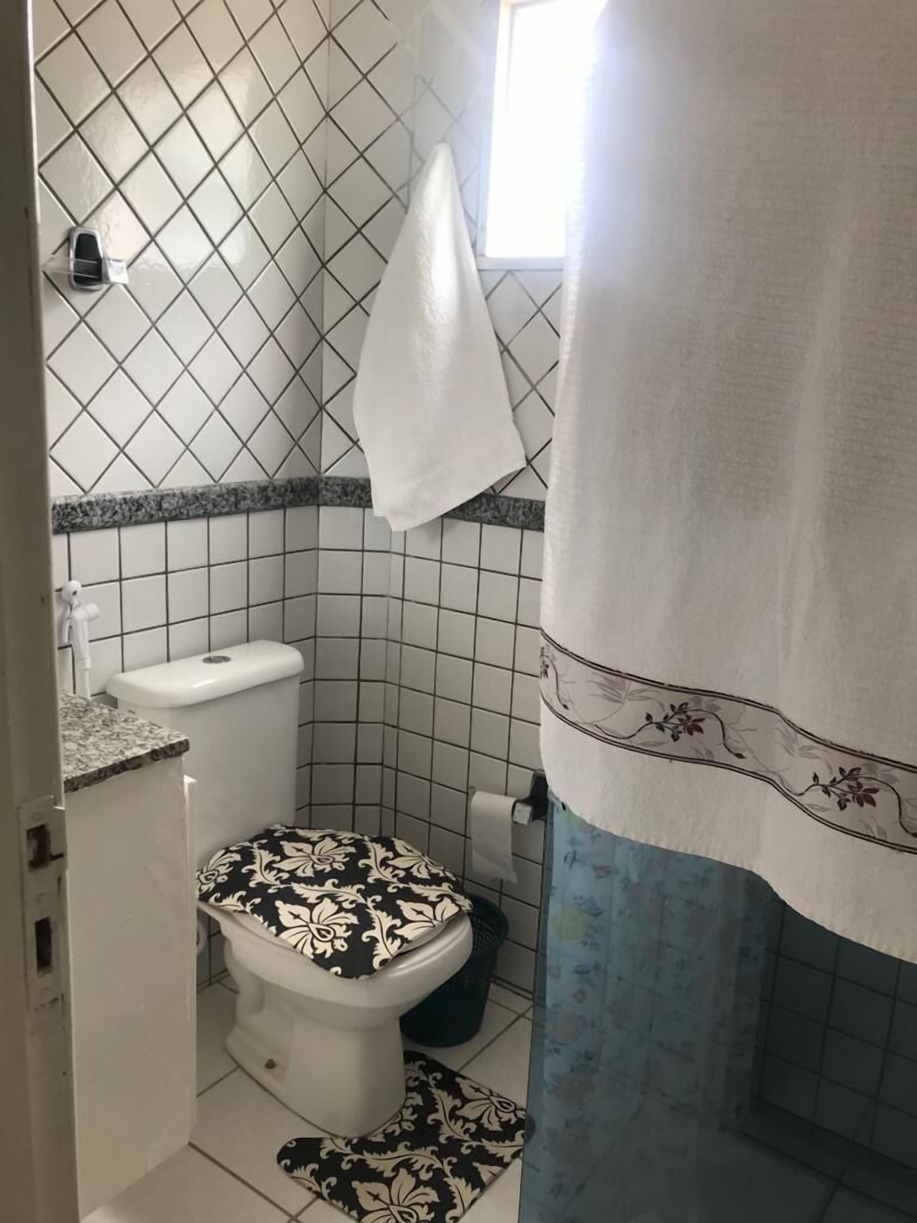 A small bathroom with a toilet, a sink, and a shower area.
