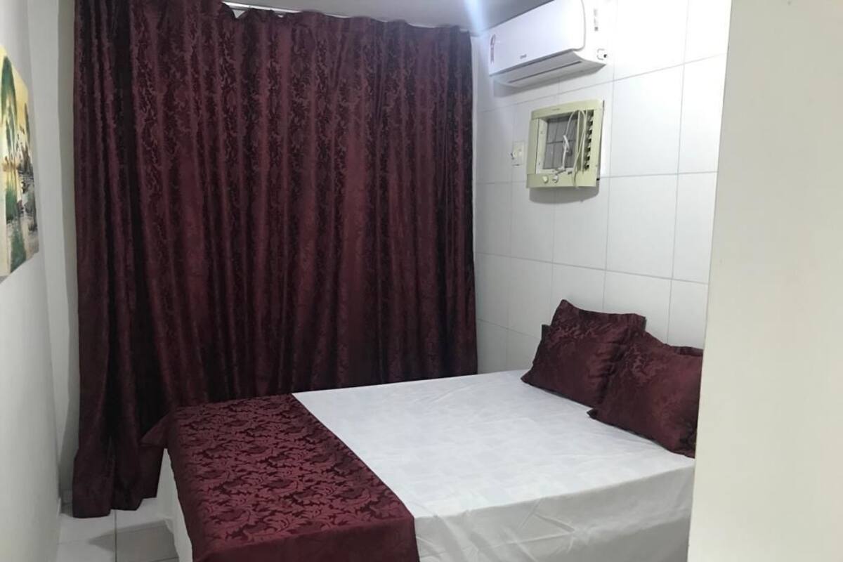 Une chambre à coucher avec un lit, une fenêtre donnant sur un beau paysage et un appareil de climatisation.