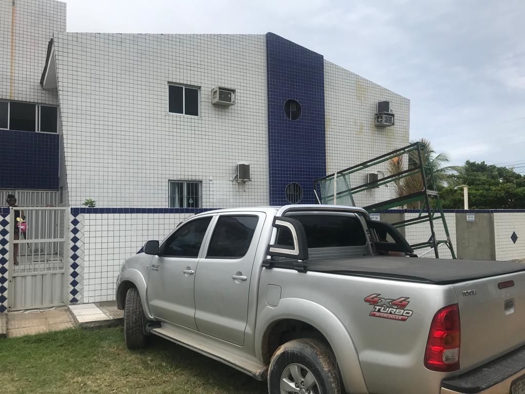 A silver pickup truck parked in front of a building with a tiled facade and a blue accent wall.