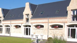 A stone building with multiple windows and a well-maintained garden. - Chemin des Dames Le Relais De Fleurette (Pontavert)
