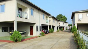 A residential street with houses, a boat, and a clear sky. - Riverside Resort Villas (Bushrod Island)
