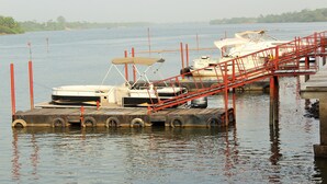 A dock with boats and a red staircase leading into the water. - Riverside Resort Villas (Bushrod Island)
