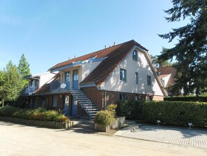 A two-story house with a staircase leading to the upper floor, a front porch, and a driveway.