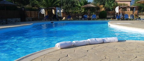 Piscine extérieure, parasols de plage, chaises longues