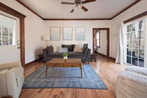 A living room with a sofa, coffee table, and a ceiling fan.