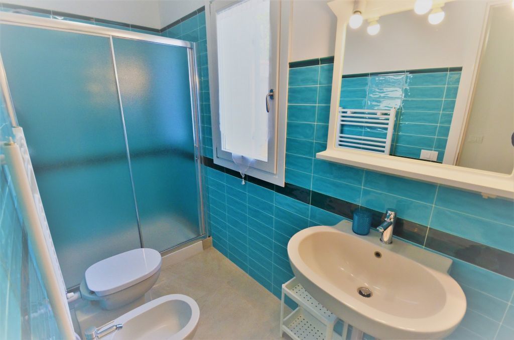 A bathroom with a toilet, sink, and shower.