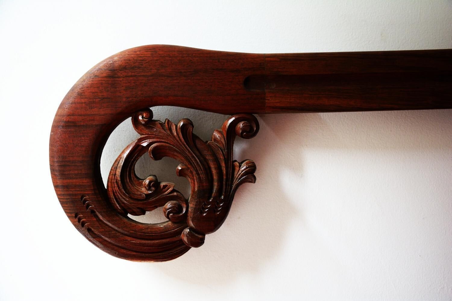 A wooden object with a carved handle and a circular design.
