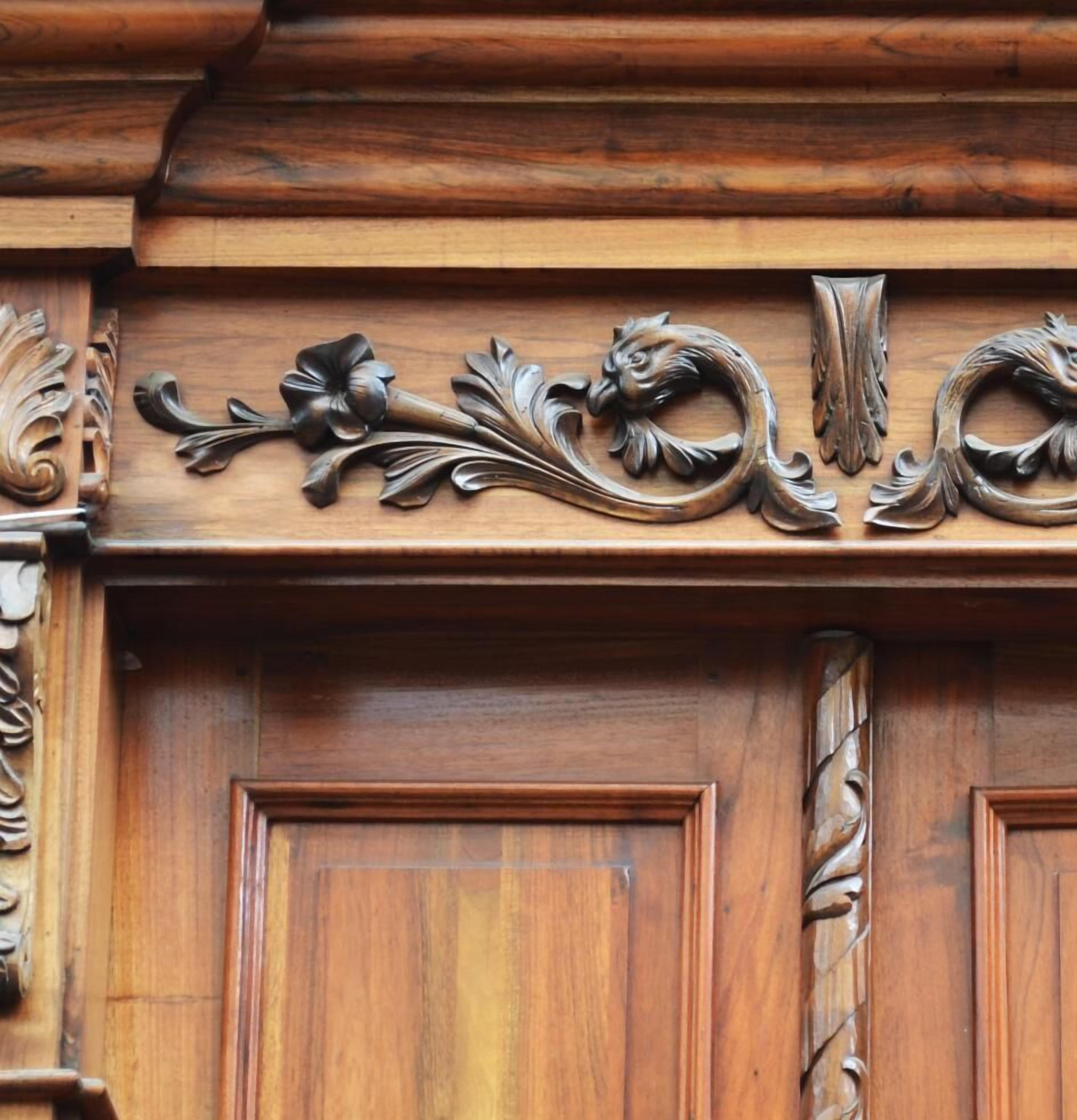 Un panel de madera con motivos florales y de hojas tallados.