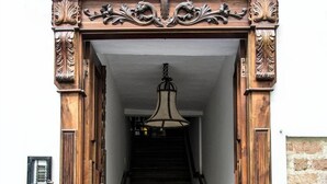 A wooden staircase with ornate carvings leading to a landing. - Hospedaje Casa Real (Salamina)
