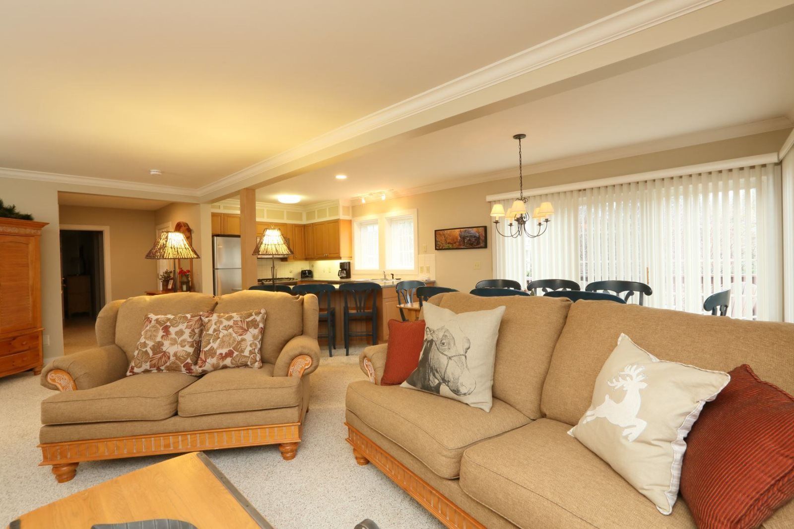 A living room with two sofas, a coffee table, and a dining area with chairs and a table.