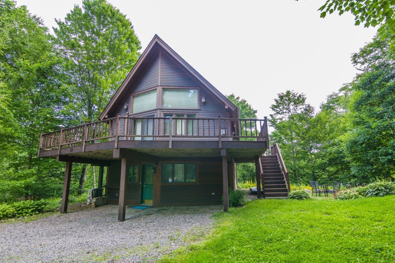 Une cabane à deux étages dotée d’un balcon et d’un escalier menant à une terrasse supérieure.