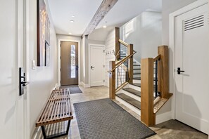 A hallway with a bench, a staircase, and a door. - 4BR Sterling Spruce Peak (Stowe)