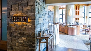 A restaurant with a stone wall and a sign reading "Solstice."