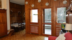 Un intérieur en bois comprenant un coin repas, un canapé rouge et un téléviseur.