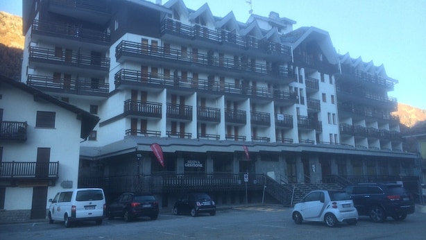 Un hôtel à plusieurs étages doté de balcons, d’un parking et d’une enseigne indiquant « NOUVELLE GÉRANCE ».