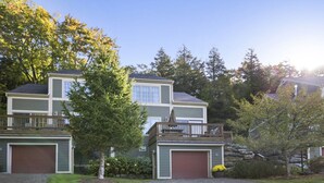 A two-story residential building with a front deck and a garage. - Americana at Topnotch Overlook (Stowe)